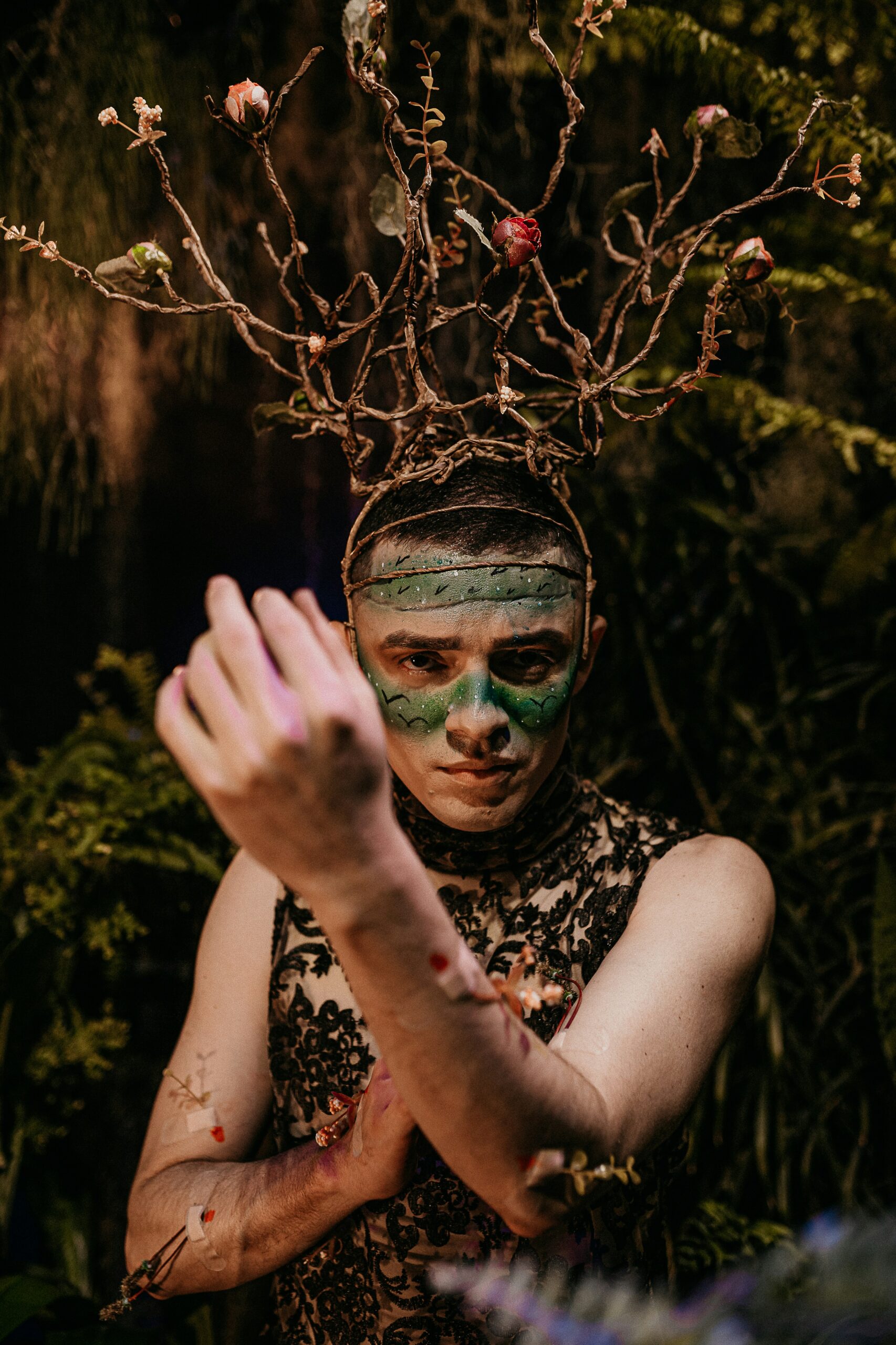 woman in black and white floral sleeveless top with green face paint